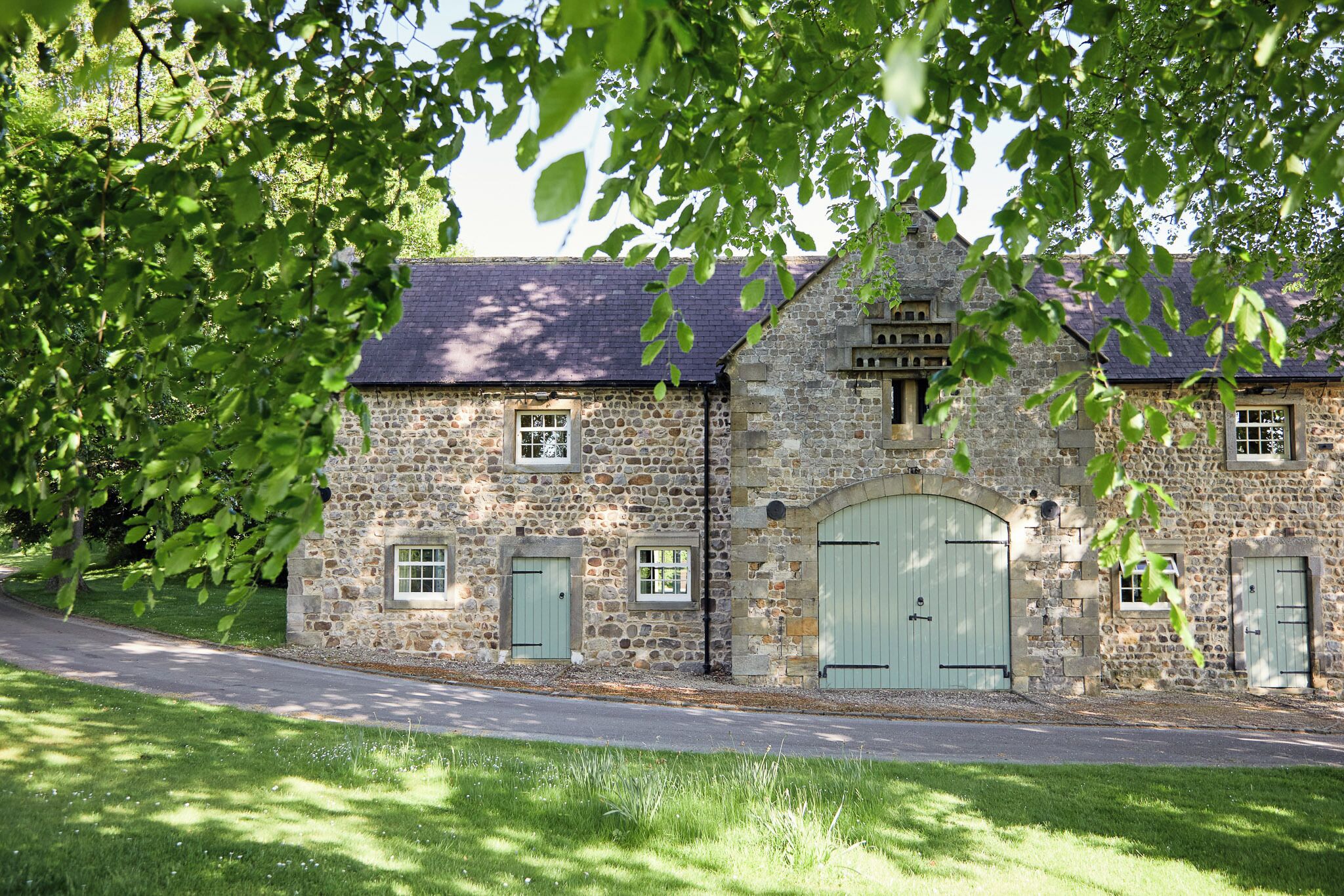 A stone building with a large arched entrance and multiple windows.