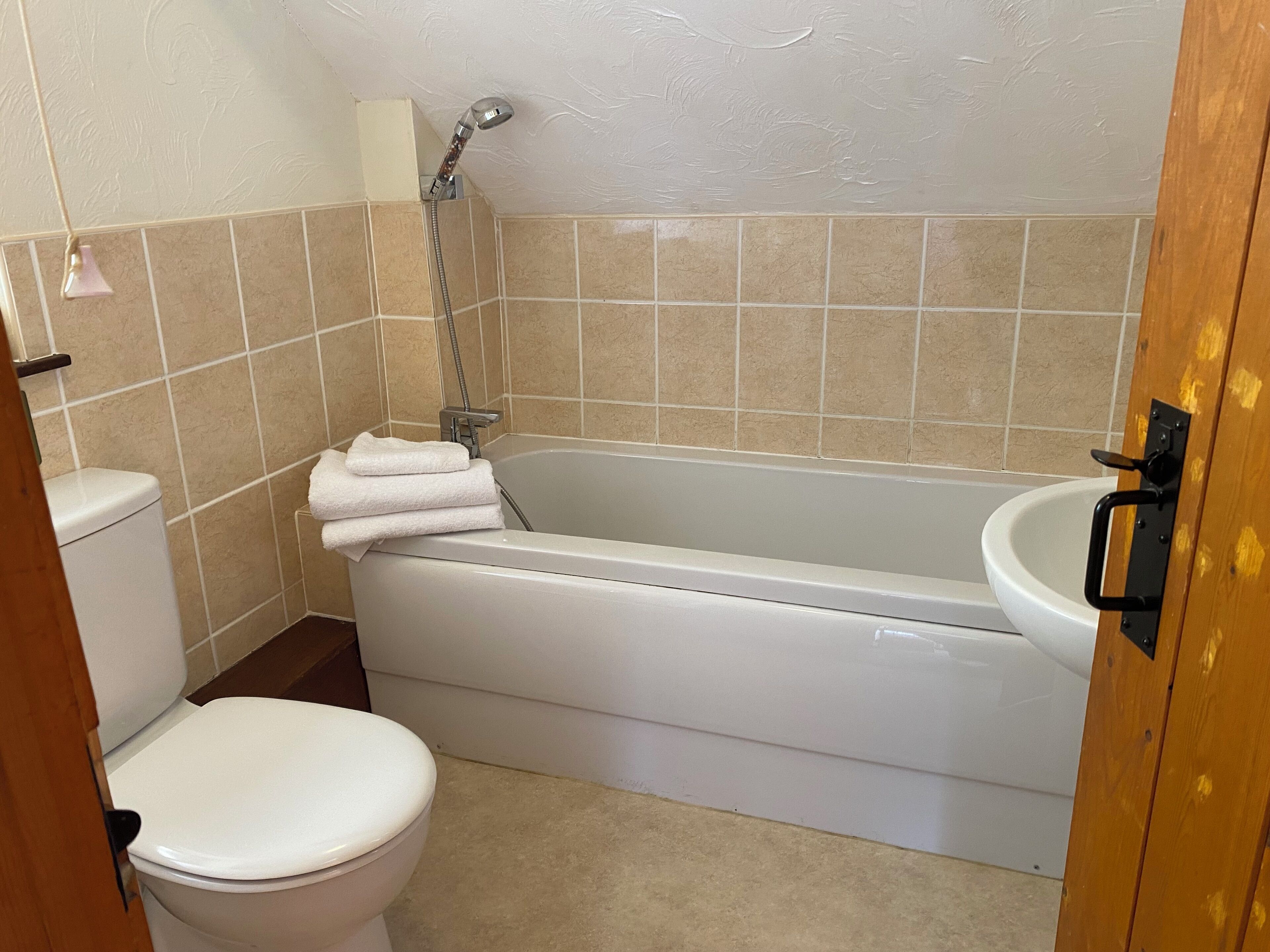 A bathroom with a bathtub, toilet, and sink.