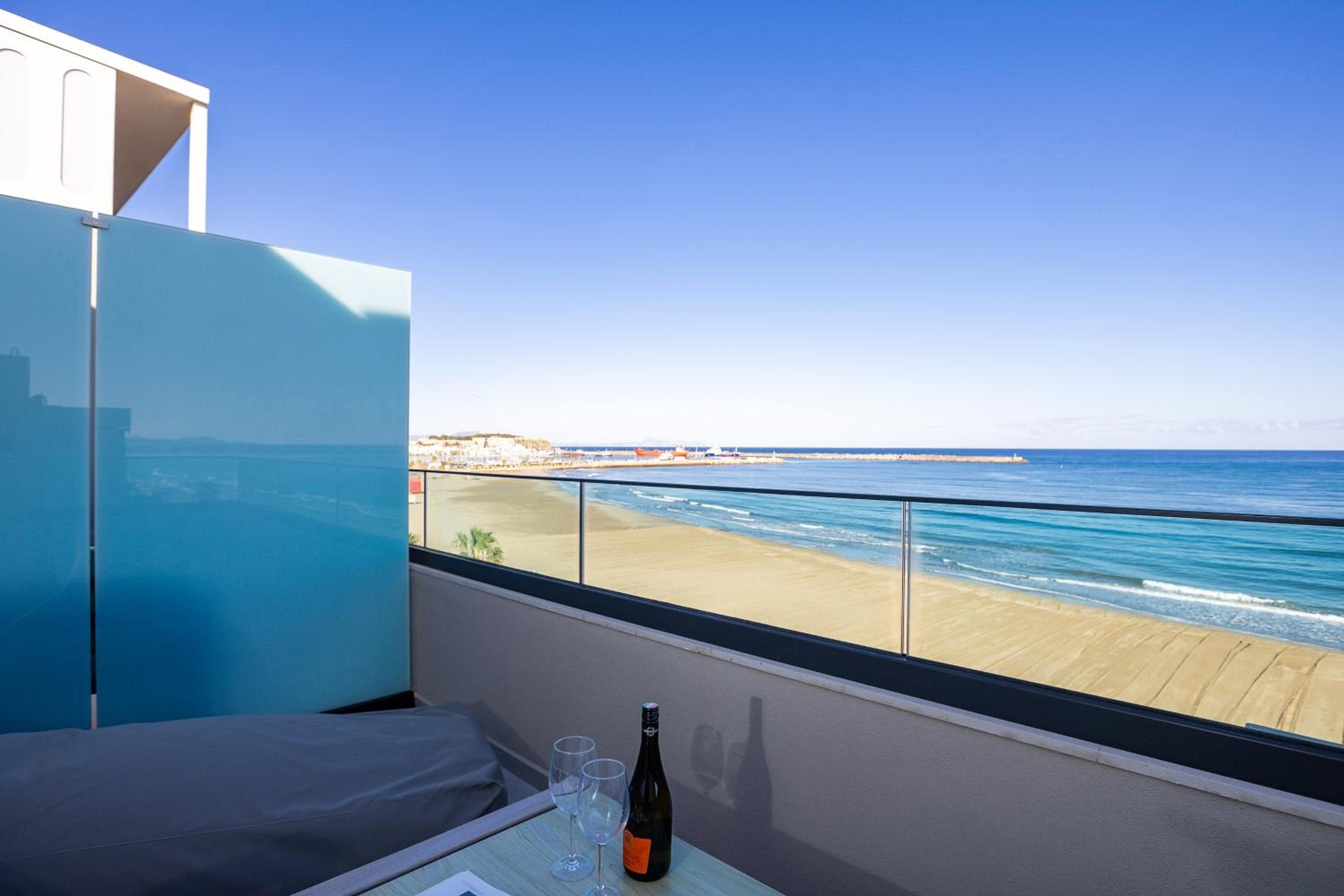 A balcony with a view of the beach and ocean.