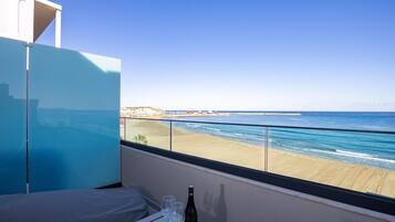 A balcony with a view of the beach and ocean.