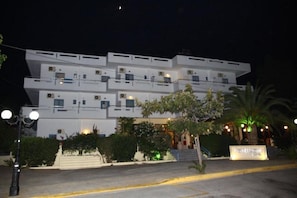 A multi-story hotel with a modern design, featuring balconies and air conditioning units. - Poseidon Hotel (Malevizi)
