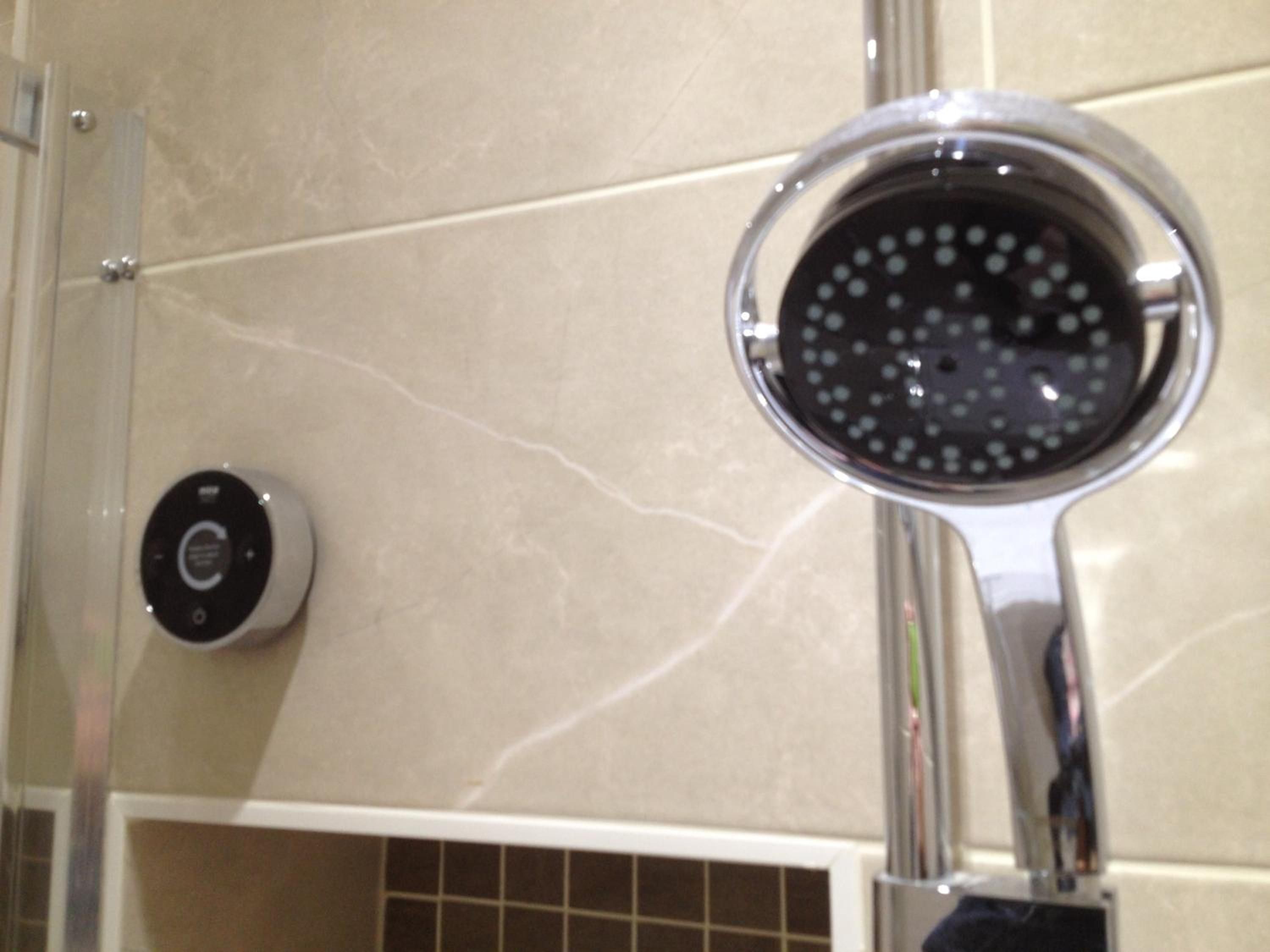Un baño con ducha y panel de control.