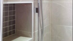 A shower with a handheld showerhead and a control panel. - LA B and B Guest Accommodation (Chichester)