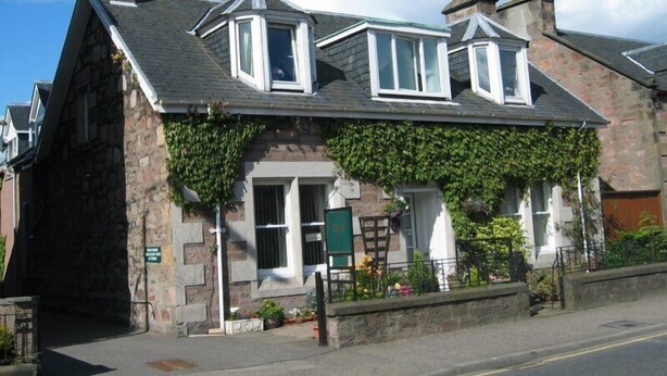 A stone building with a gabled roof, dormer windows, and ivy-covered walls. - Mardon Guest House (Inverness)