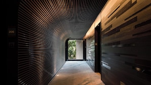 A corridor with a modern design, featuring a patterned floor and a slatted ceiling. - Aloft Taipei Zhongshan (Taipei)