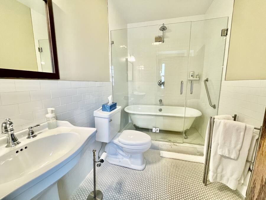 A modern bathroom with a glass-enclosed shower, a freestanding bathtub, and a standard toilet.