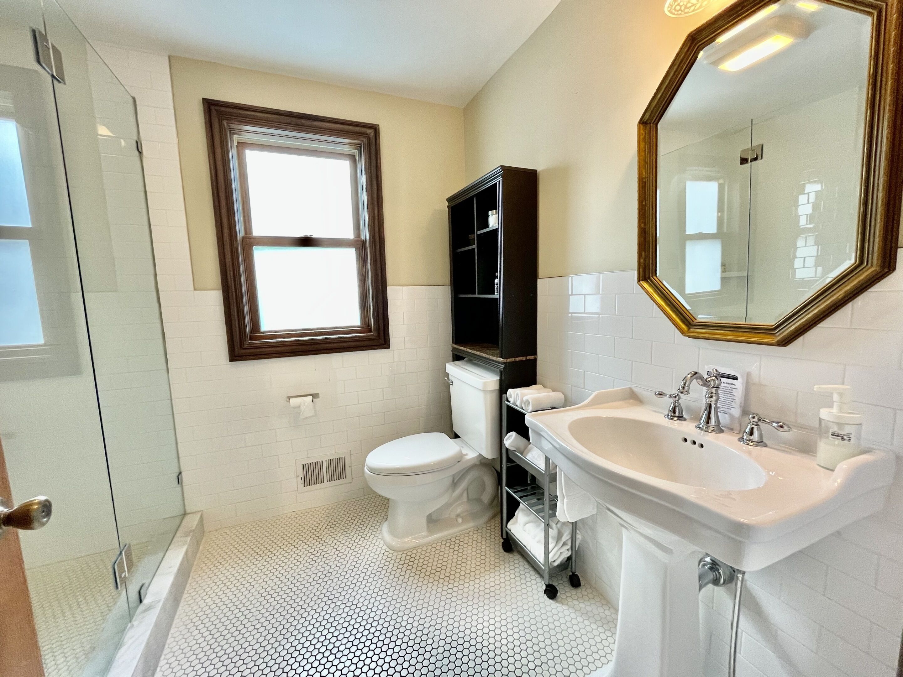 A bathroom with a toilet, sink, and shower.