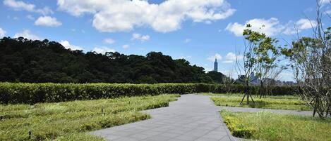 Un sendero pavimentado en un parque con una vista distante de una torre.
