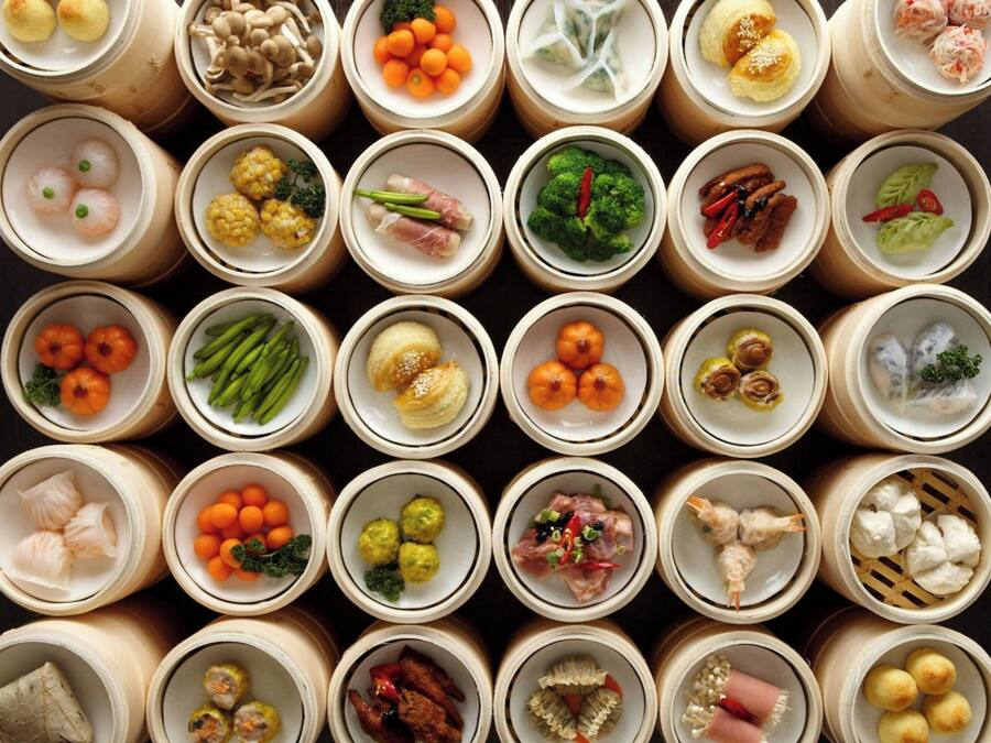 A top-down view of a variety of food items arranged in bamboo containers.