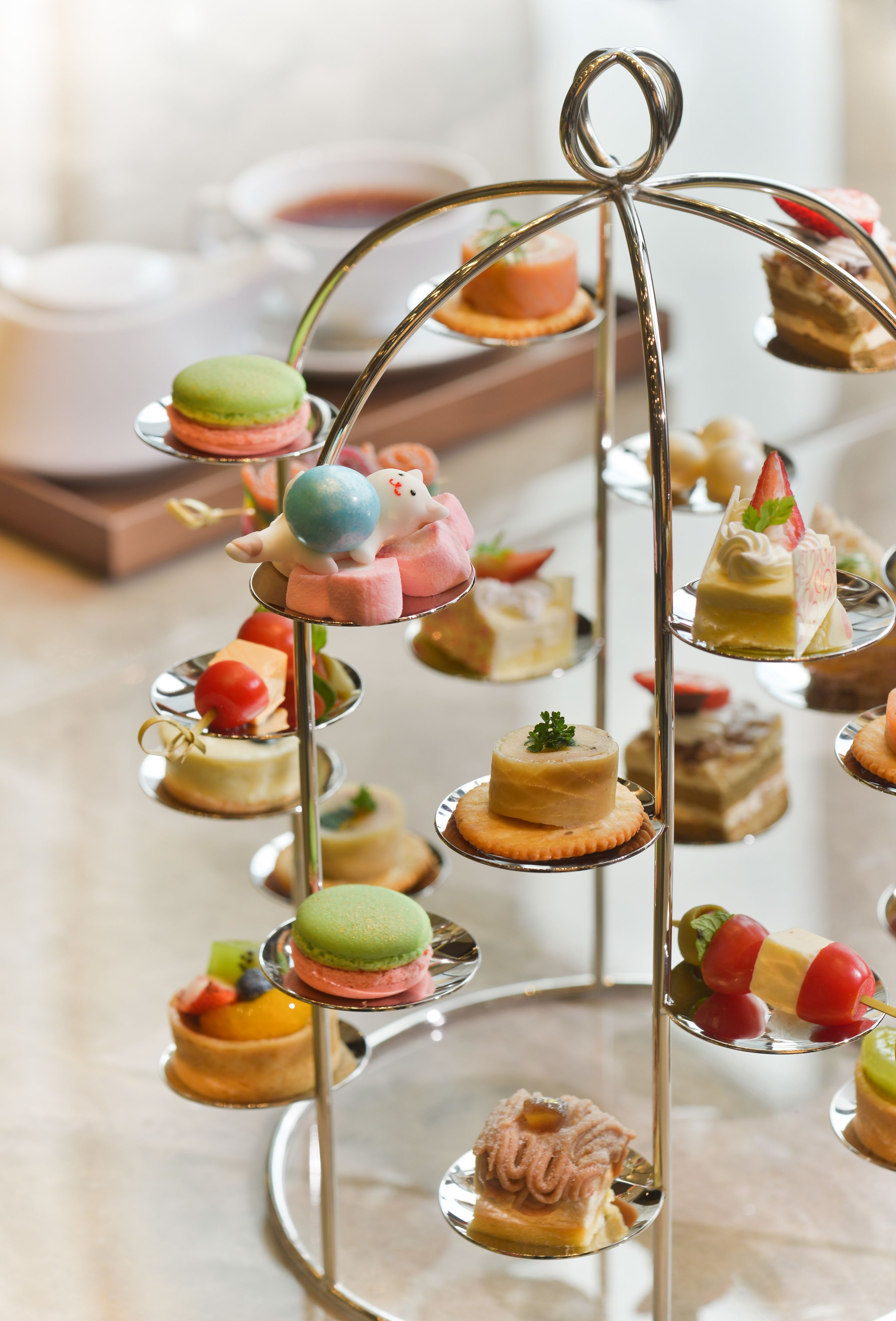 A tiered dessert display with various pastries and macarons.