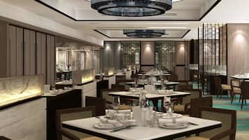 Een modern restaurant met meerdere eettafels, elegante kroonluchters en een stijlvol interieur.