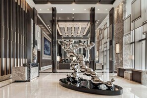 A modern lobby with a reflective sculpture, marble flooring, and a high ceiling with recessed lighting. - Courtyard by Marriott Taipei (Taipei)