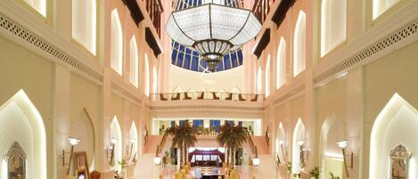 A spacious lobby with a central seating area, multiple seating options, and a large chandelier.