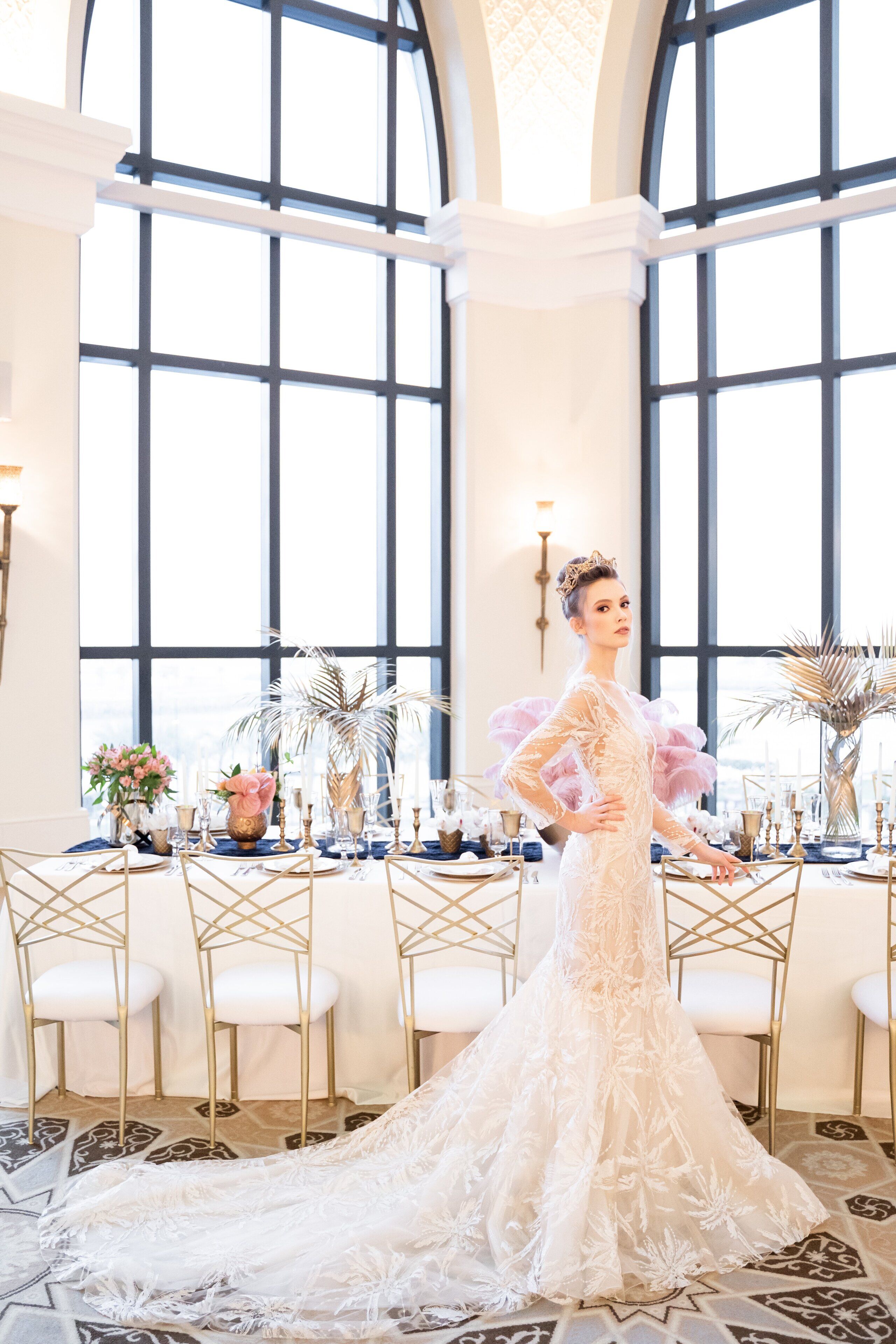 A wedding dress on a table with a large window in the background.