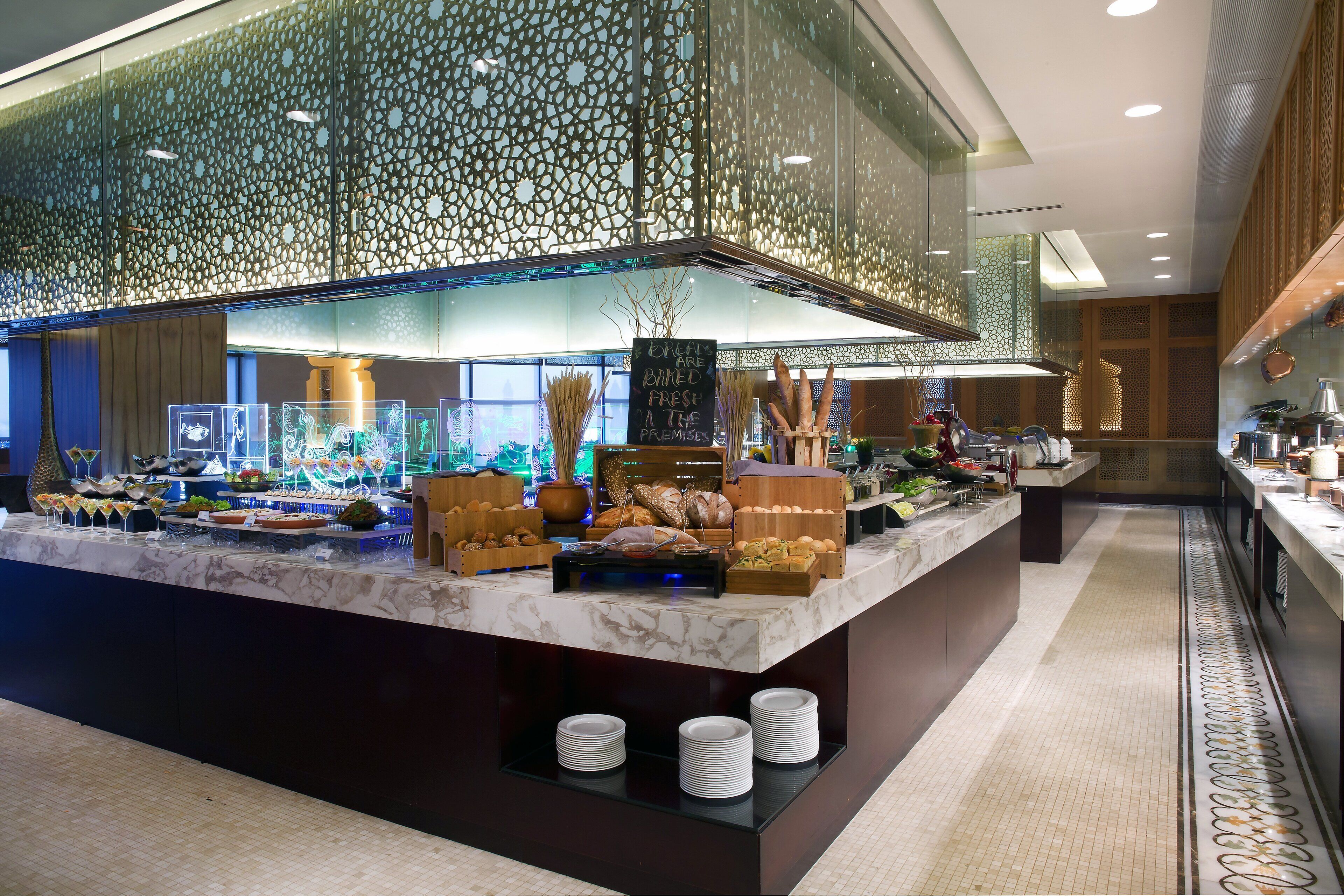 A buffet setup with various food items and a sign indicating fresh baked goods.