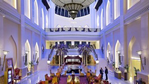Spaziosa hall con scala centrale, zone relax e reception.