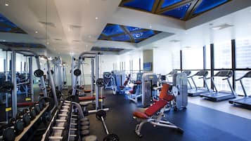 A gym with various exercise equipment, large windows, and a skylight.