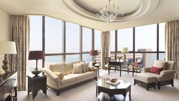 A spacious living room with a large window, a chandelier, and a view of the city.