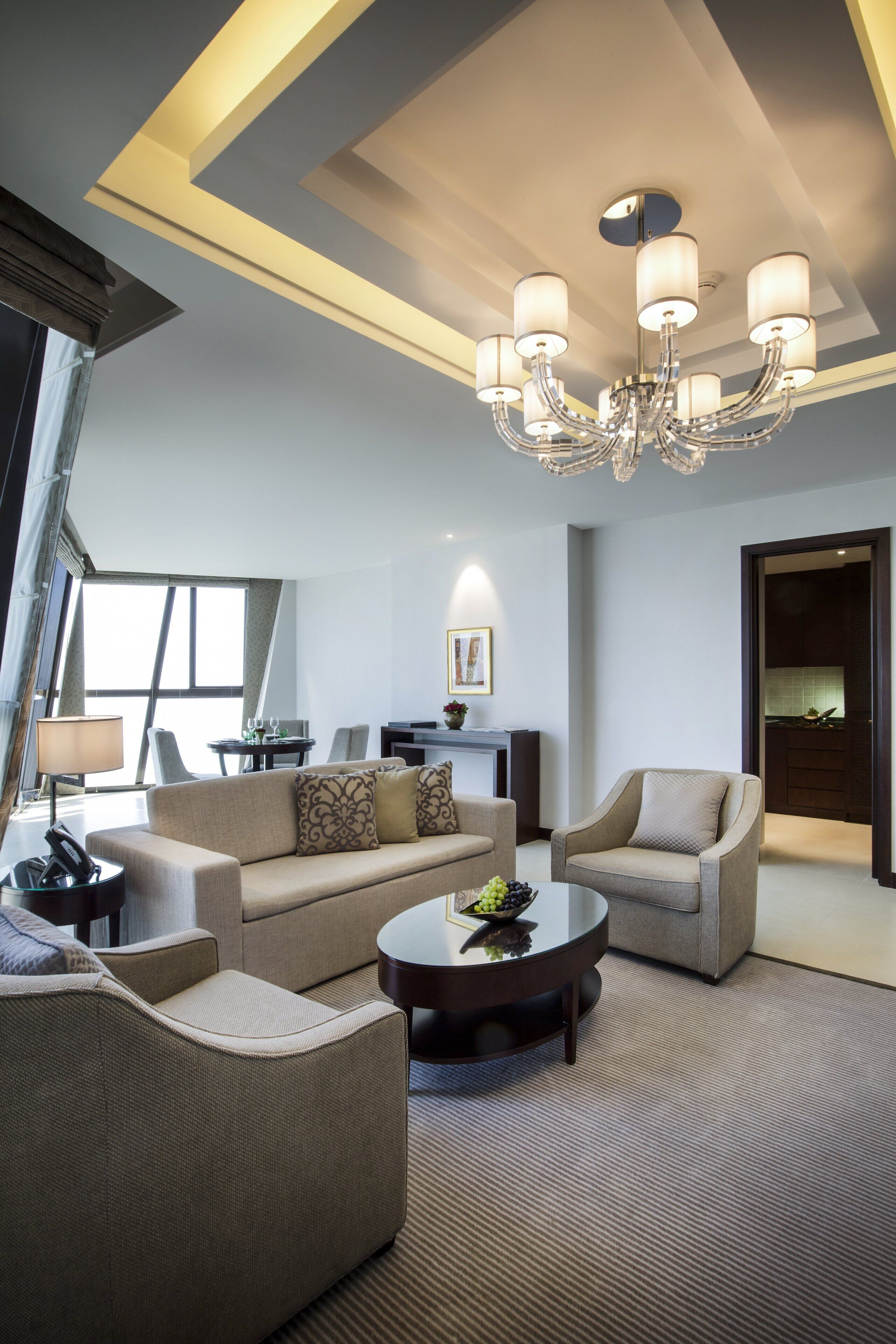 Uma sala de estar moderna com um candelabro, sofás e uma mesa de centro.