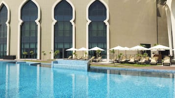 Een buitenzwembad, parasols voor strand/zwembad