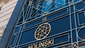 Fachada de edificio con un llamativo letrero '16' y 'NOLINSKI', que presenta patrones geométricos y balcones.