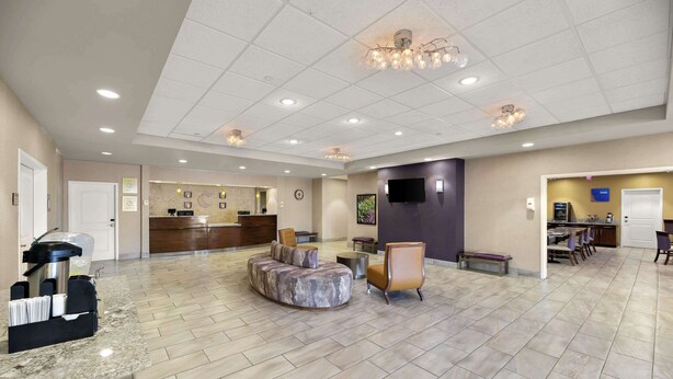 A spacious lobby with a reception desk, seating area, and a dining section.