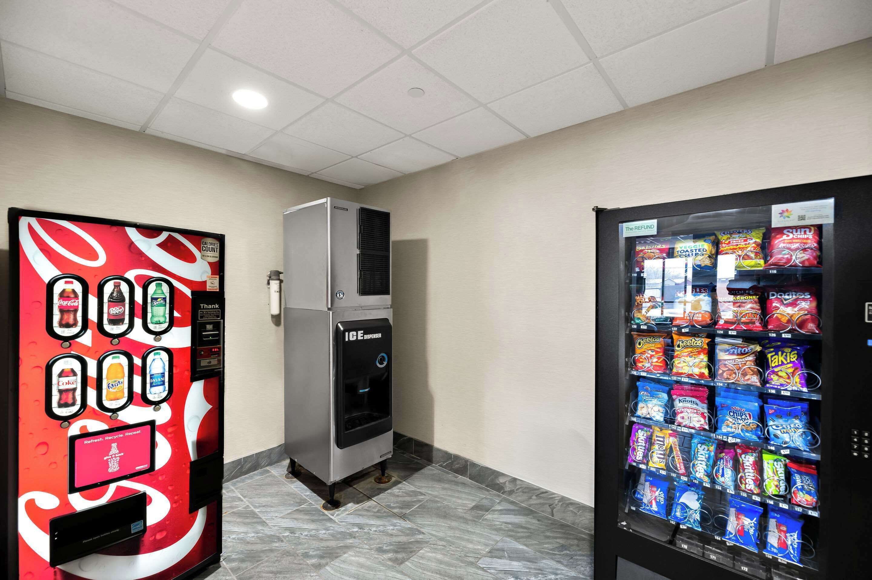 A vending machine area with a beverage dispenser, a water cooler, and a snack vending machine.