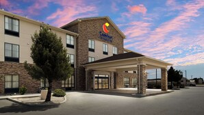 A Comfort Inn & Suites with a stone facade, a covered entrance, and a parking lot.