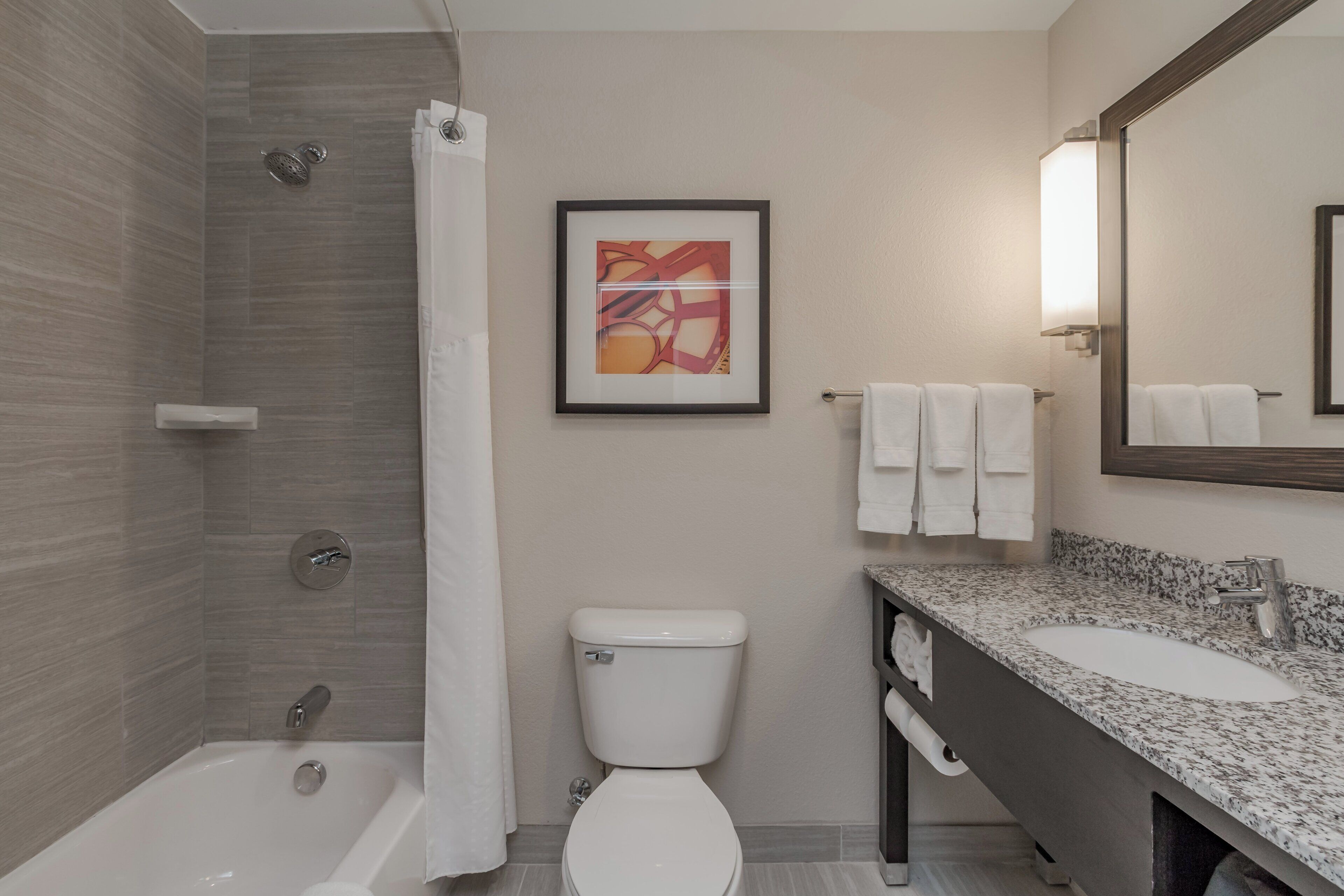 A modern bathroom with a bathtub, toilet, and sink.