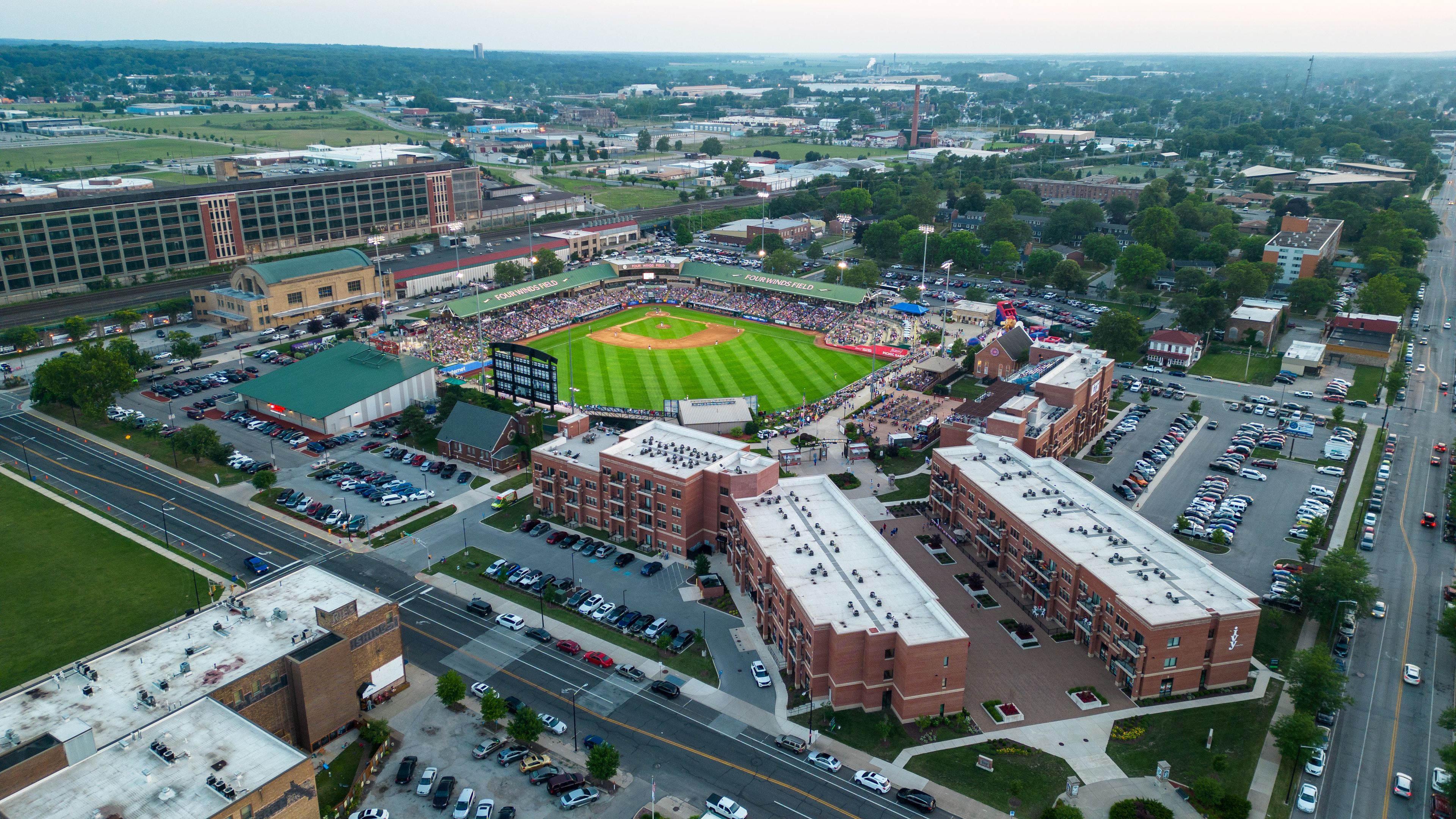 An aerial view of a stadium surrounded by parking lots and buildings.