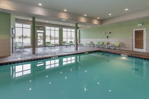 Una piscina techada, sillones reclinables de piscina