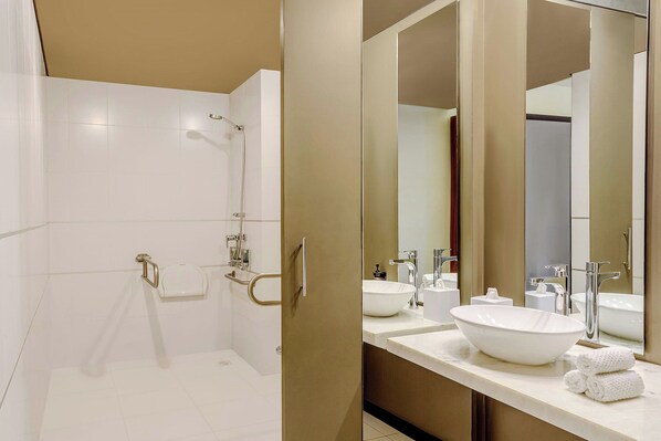 A modern bathroom with a walk-in shower, two sinks, and a large mirror. - Aloft by Marriott Asuncion (Asunción)