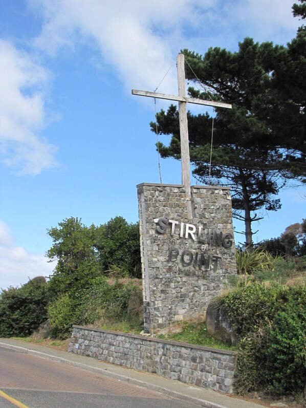 A stone sign with the text "Stirling Point" and a wooden cross above it. - Lands End Boutique Hotel (Bluff)