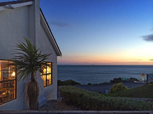 A coastal house with a view of the ocean at dusk. - Lands End Boutique Hotel (Bluff)