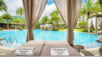 Alberca techada, alberca al aire libre y sombrillas en la alberca