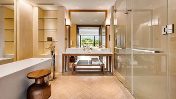 A modern bathroom with a large mirror, a wooden vanity, and a glass shower enclosure.