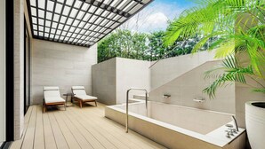 Une salle de bain extérieure moderne, dotée d’une grande baignoire, de deux fauteuils de relaxation et d’une pergola.
