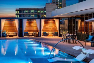 Una piscina al aire libre, sillones reclinables de piscina