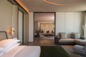 A modern hotel room with a large bed, a sitting area with a sofa and chairs, and a dining table. - Shenzhen Marriott Hotel Nanshan (Shenzhen)