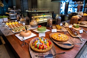 Desserts are presented on individual plates and wooden boards, accompanied by serving utensils.