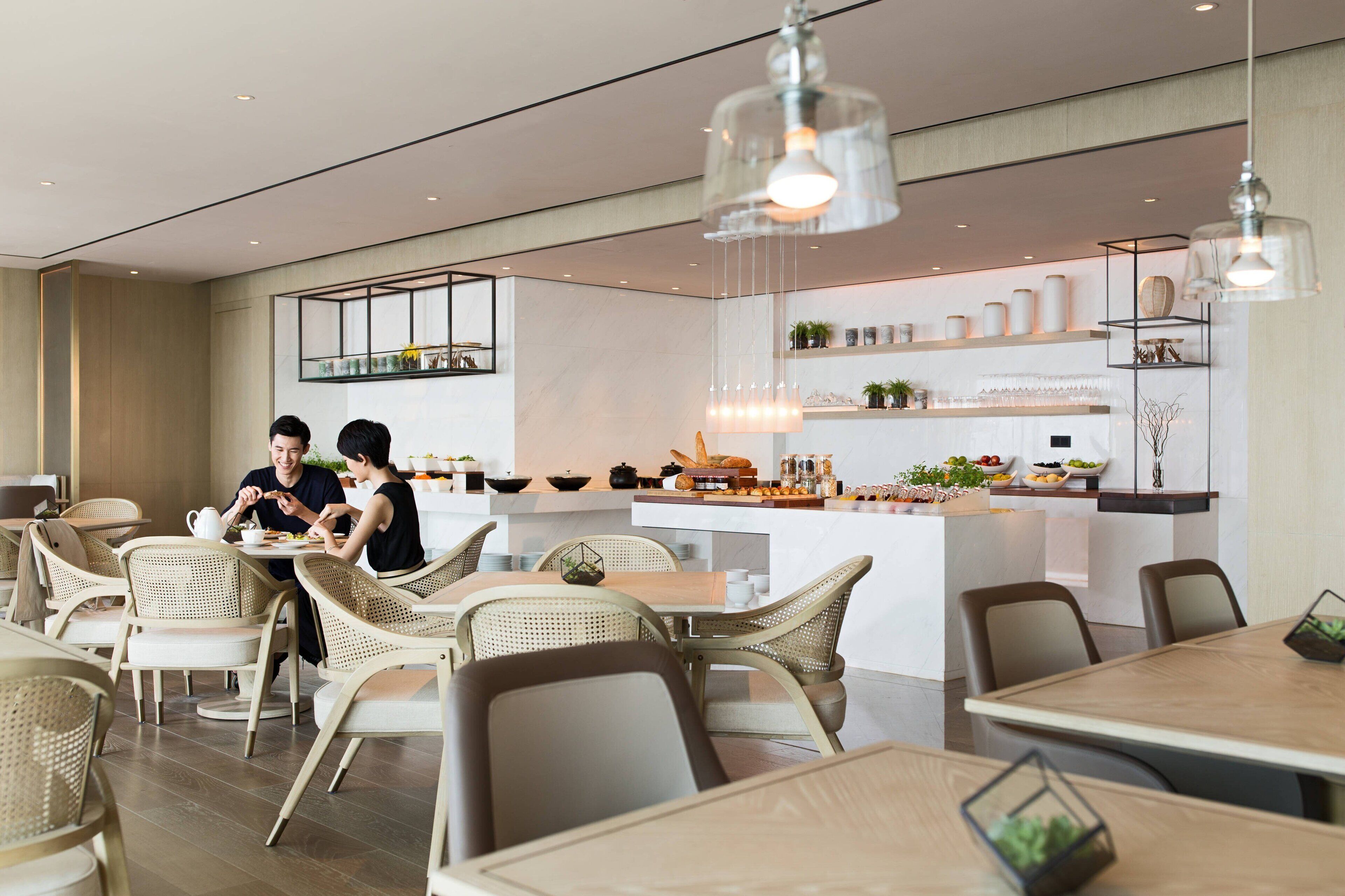 A modern dining area with wicker chairs and a central island with a kitchen counter.