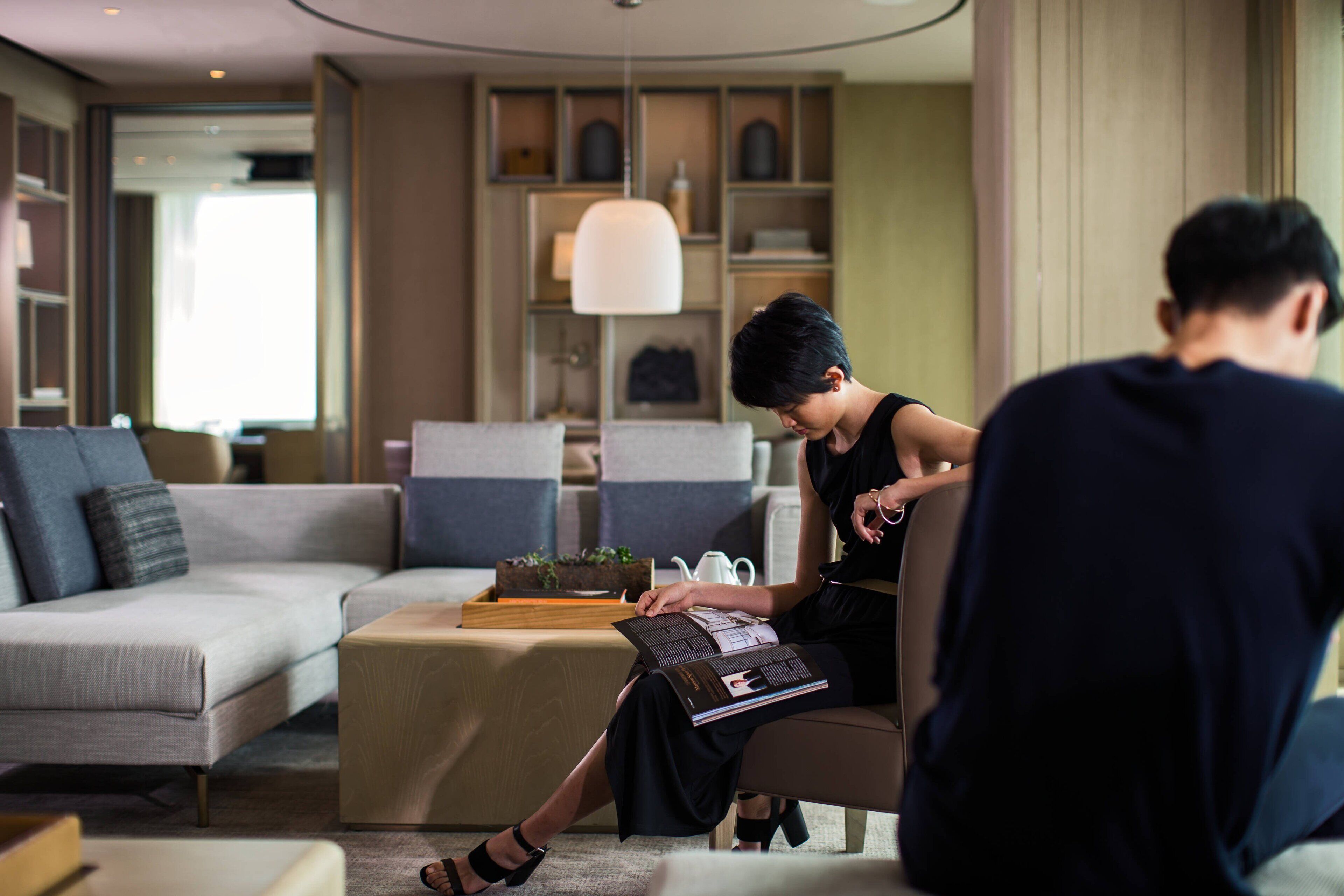 A modern living room with a sofa, a coffee table, and a bookshelf.