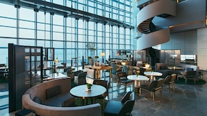 A spacious lobby with a modern design, featuring a large glass wall, a spiral staircase, and multiple seating areas. - Shenzhen Marriott Hotel Nanshan (Shenzhen)