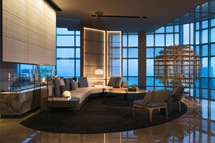 Un interior moderno con una zona de estar curva, un separador de vidrio y una estructura decorativa de madera.