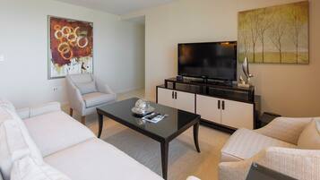 Ein modernes Wohnzimmer mit Flachbildfernseher, Couchtisch und Sofa.
