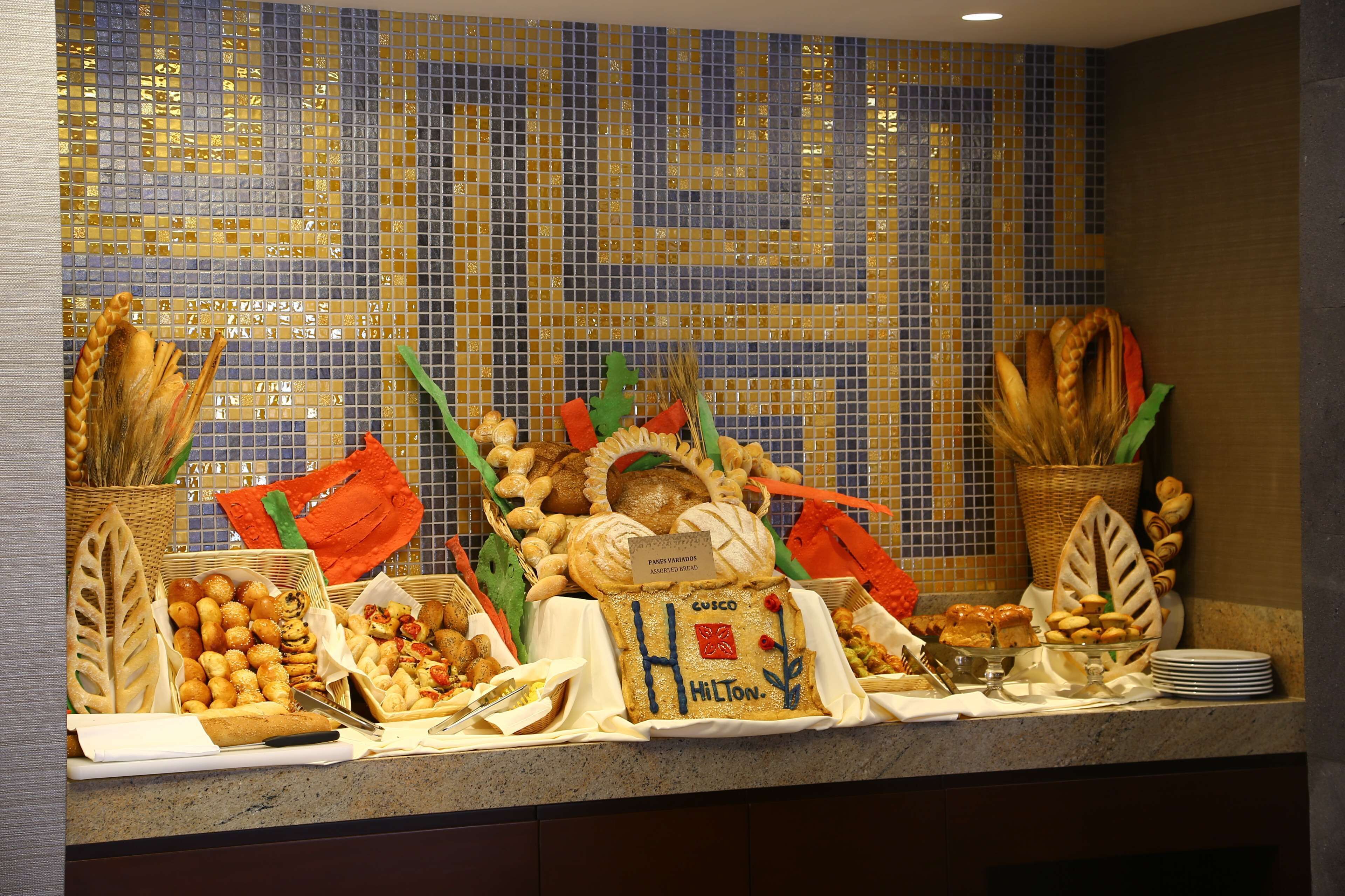 A buffet with various breads and pastries.