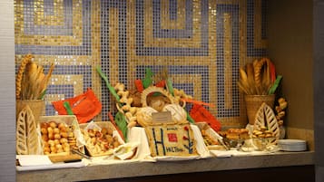 Un buffet proposant une variété de pains et de viennoiseries.