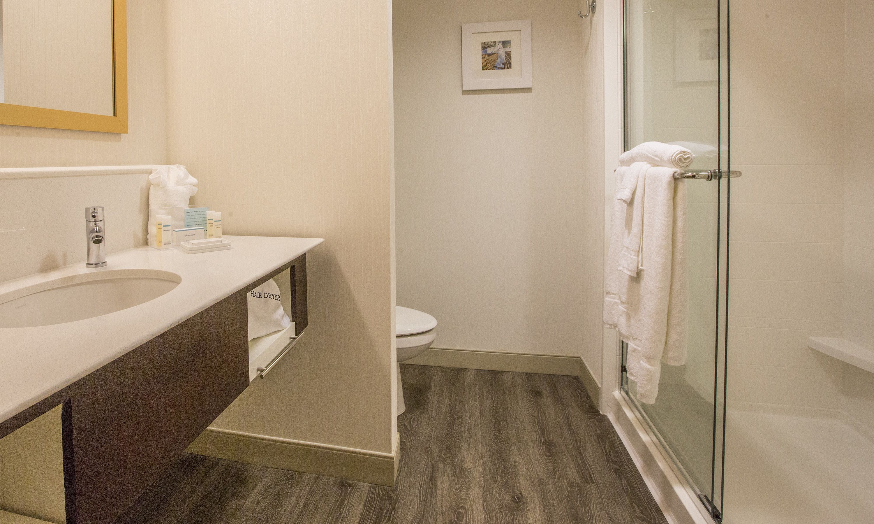 A bathroom with a sink, toilet, and glass shower enclosure.