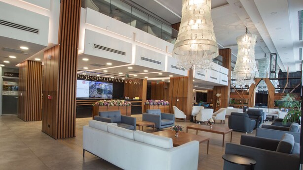 A spacious lobby with a modern design, featuring a large seating area with sofas and armchairs, a reception desk, and a chandelier. - Hilton Garden Inn Ankara Gimat (Ankara)