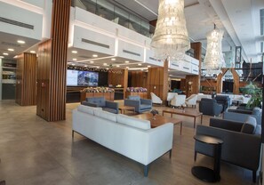 A spacious lobby with a modern design, featuring a large seating area with sofas and armchairs, a reception desk, and a chandelier. - Hilton Garden Inn Ankara Gimat (Ankara)